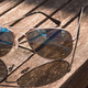 A pair of aviator sunglasses on a table.